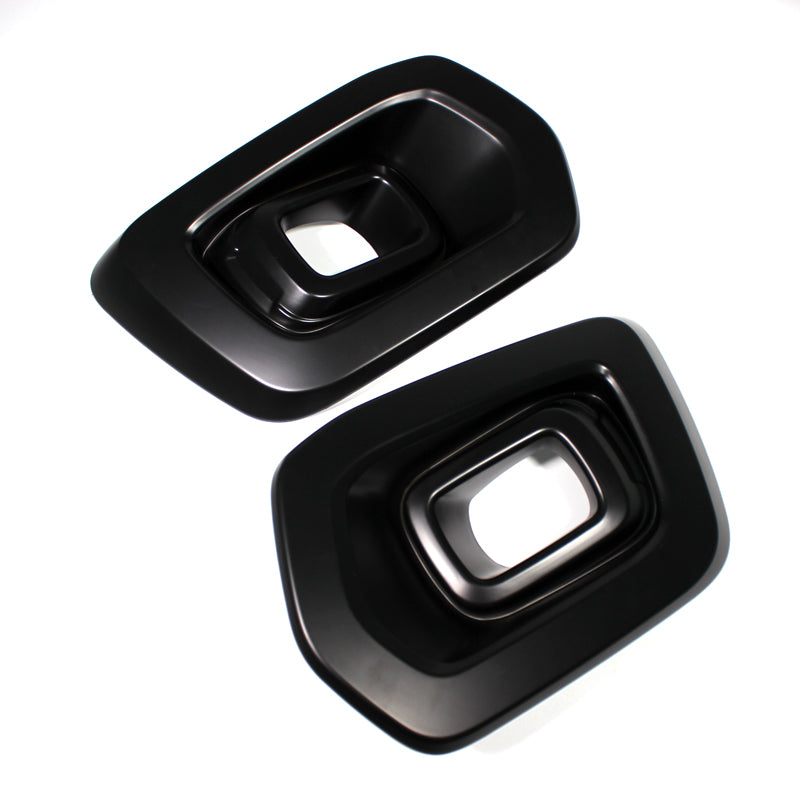 Two shiny black rectangular exhaust tips with beveled edges positioned next to each other on a plain white background, arranged at an angle.