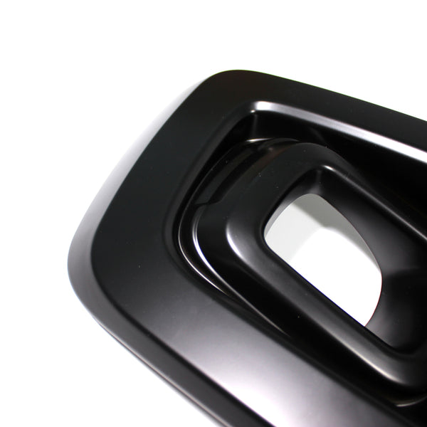 A glossy black, rectangular, hollowed-out object with rounded edges appears against a plain white background, featuring layered, concentric shapes.