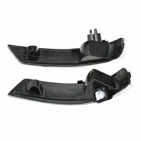 Two black plastic car light covers, each with a curved shape and mounting points, are positioned horizontally on a white background.