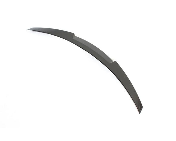 A curved, dark-colored blade-like object lies flat on a plain white background. It features a smooth surface with slightly angled edges, suggesting a sleek, aerodynamic design.