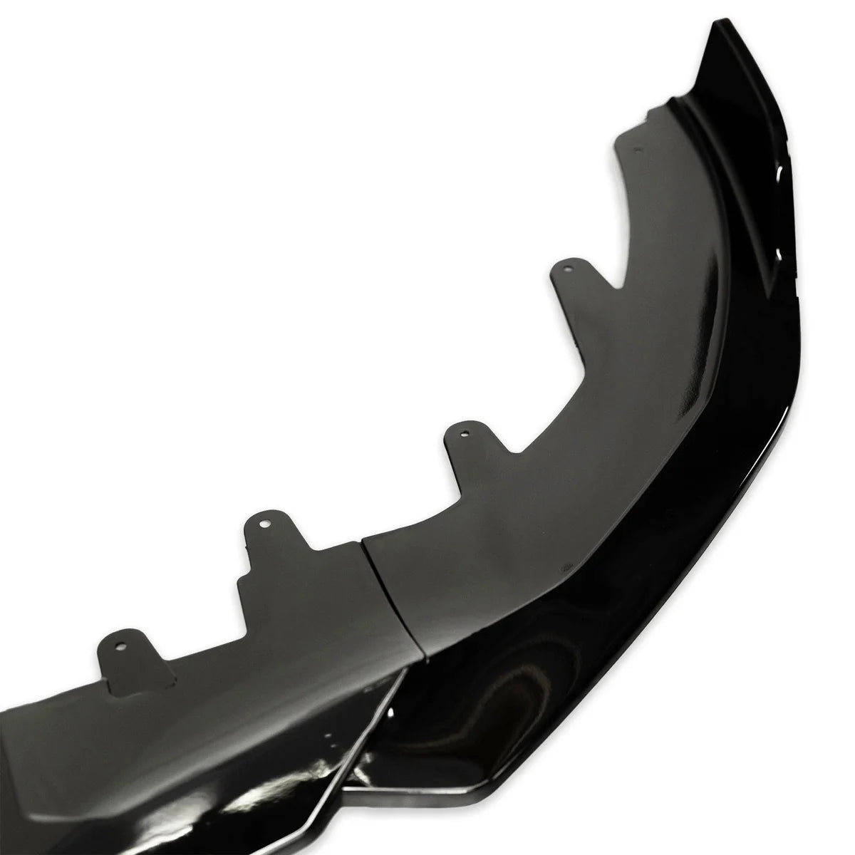 A black car front splitter, featuring multiple mounting tabs, is shown in close-up on a white background, highlighting its glossy finish and aerodynamic design.