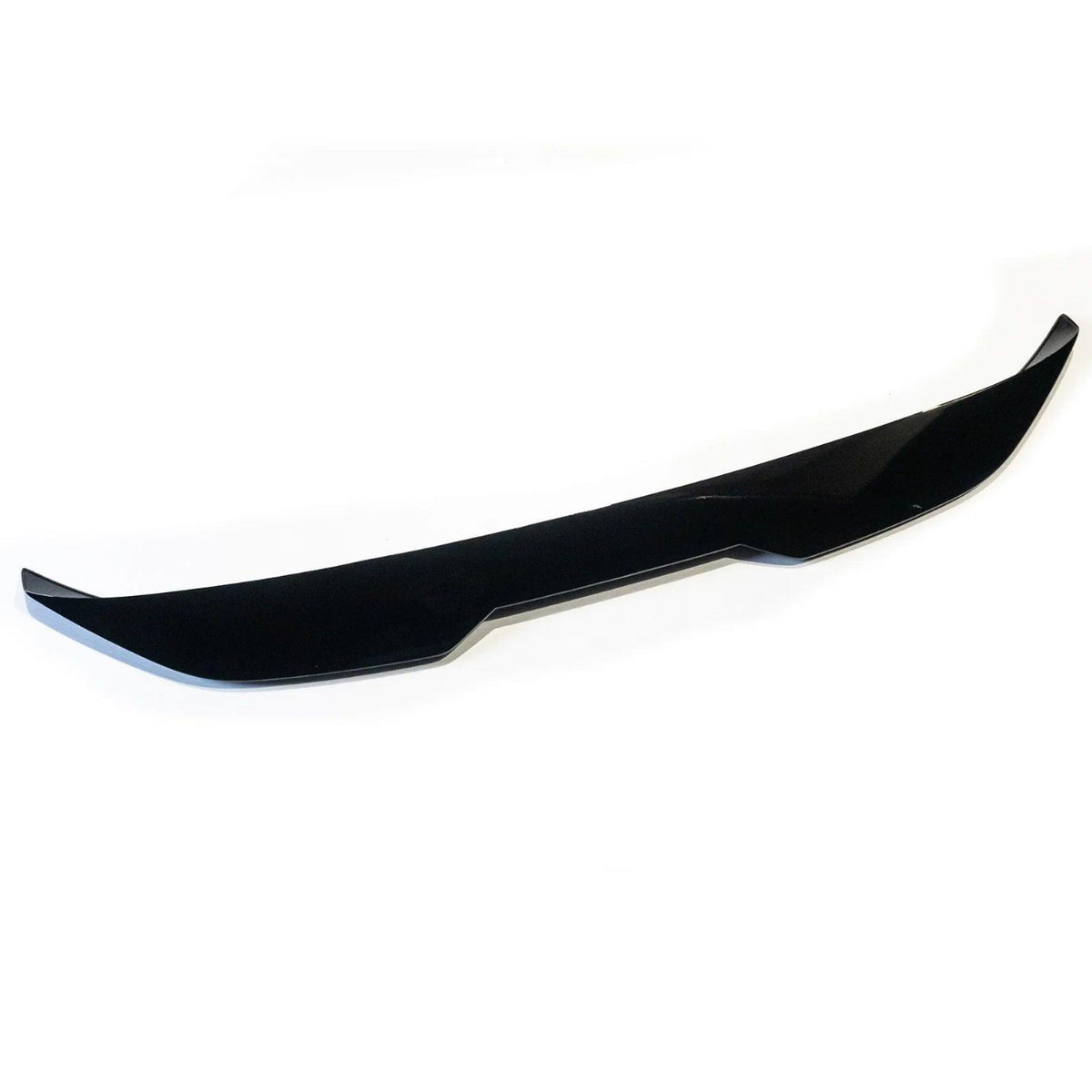 A sleek, black car front lip spoiler rests on a white background, featuring sharp edges and a subtle curvature designed to improve aerodynamics.