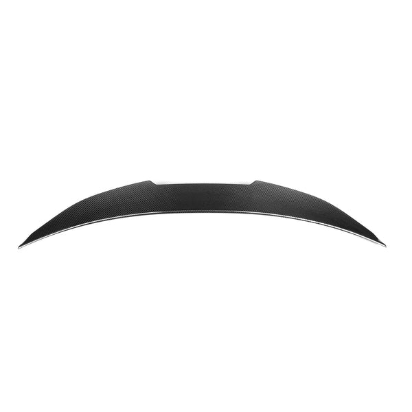 A curved, elongated carbon fiber spoiler with a sleek design lies against a plain white background.