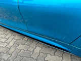 A blue car door reflects its smooth, shiny surface on a brick-paved ground, showcasing a sleek design without visible text.