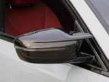 Side mirror: A sleek, black side mirror extends from a white car, reflecting its surroundings. The car interior features red upholstery visible through the window.