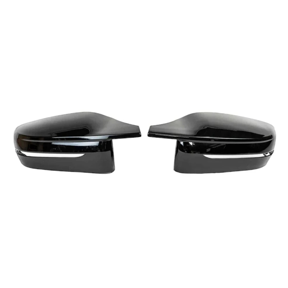 Two black side mirror caps are positioned facing each other on a plain white background. Each has a glossy finish and a silver trim line near the bottom.