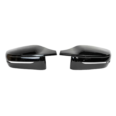 Two black side mirror caps are positioned facing each other on a plain white background. Each has a glossy finish and a silver trim line near the bottom.