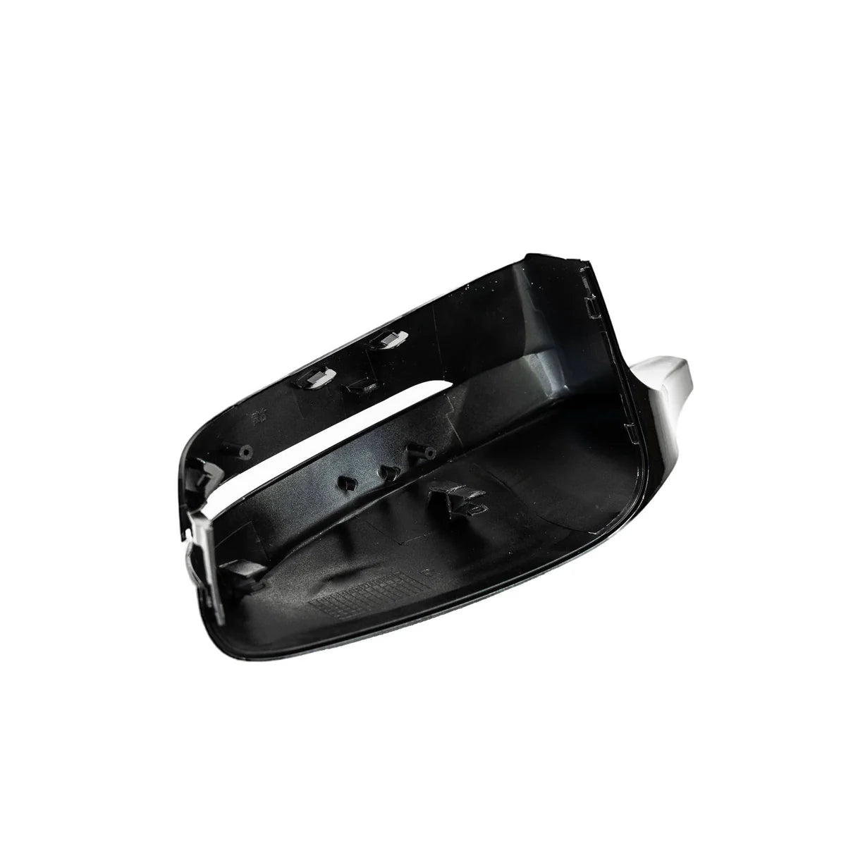 A black, unpainted car side mirror cap with attachment points sits against a plain white background, showcasing its interior features and edges.