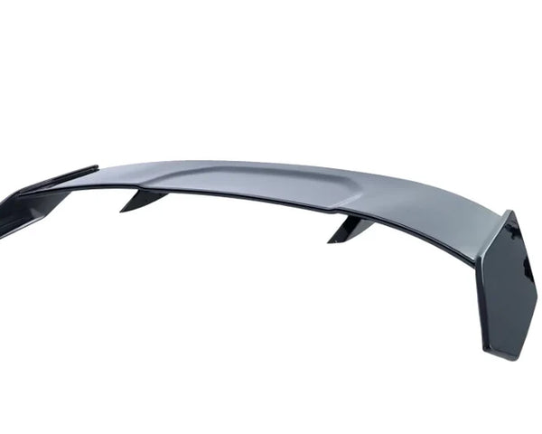A sleek, curved car spoiler with angular edges and two side supports is displayed against a plain white background, emphasizing its aerodynamic design.