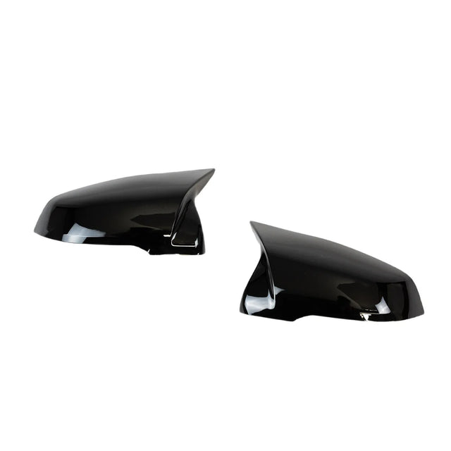 Two shiny black side mirror covers are positioned facing each other against a white background, highlighting their sleek, aerodynamic design.