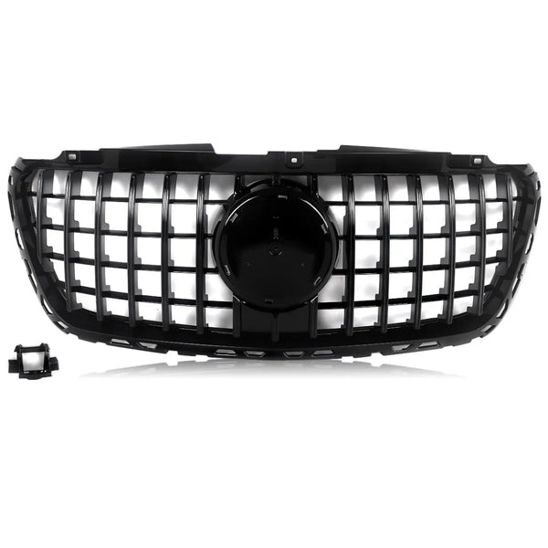 A black car grille features a grid design with a central circular emblem area, set against a white background. A detached rectangular component is located in the lower left corner.