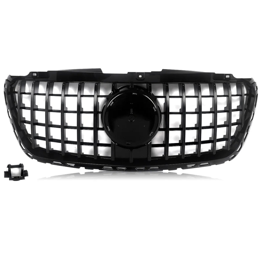 A black car grille features a grid design with a central circular emblem area, set against a white background. A detached rectangular component is located in the lower left corner.