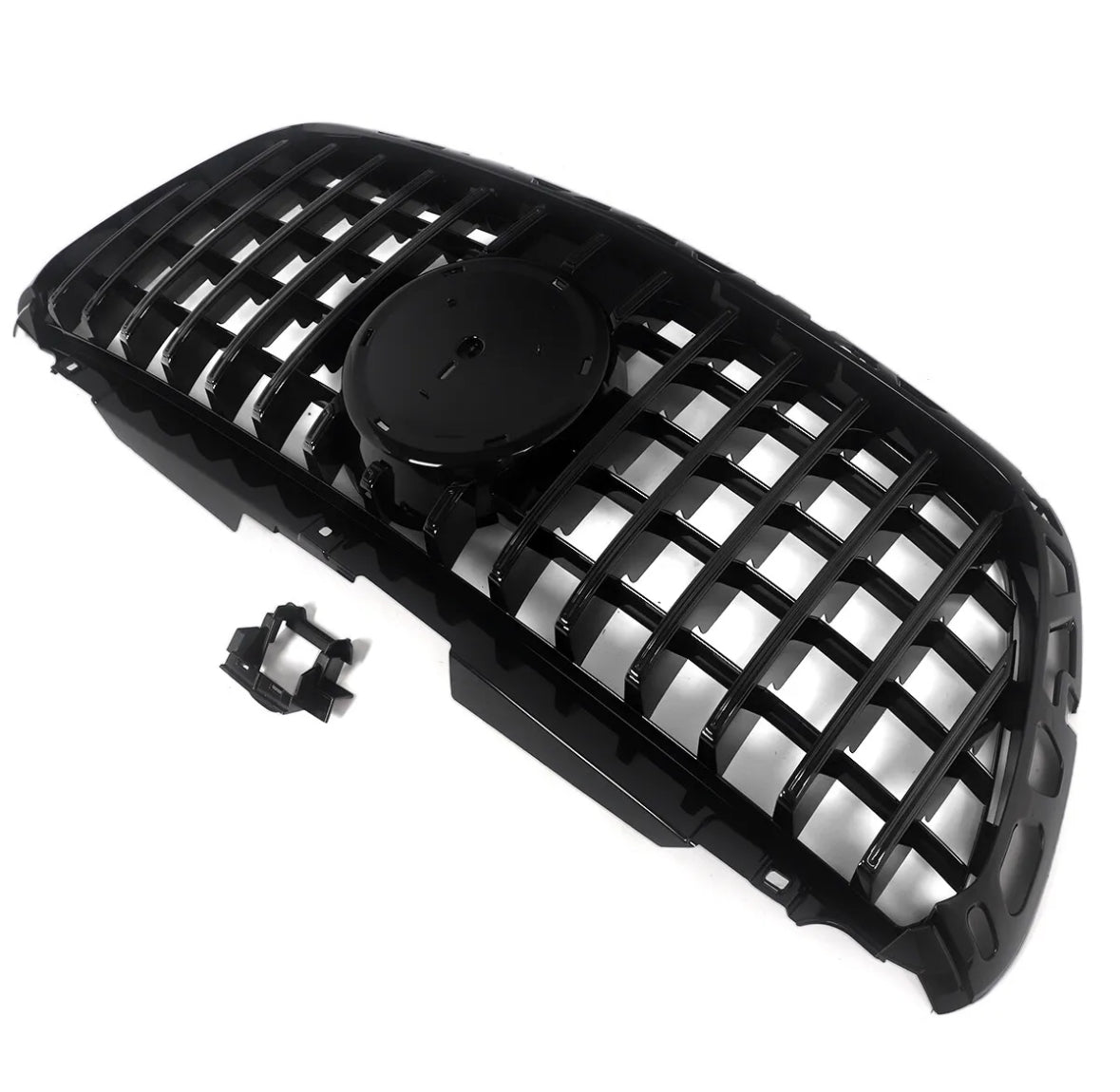 A black car grille with a mesh design lies on a white background. It features a central circular mount for an emblem, accompanied by an additional small attachment piece nearby.
