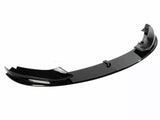 A sleek, black car front lip spoiler is resting on a plain, white background. It features a curved aerodynamic design, often used for reducing drag and enhancing vehicle performance.