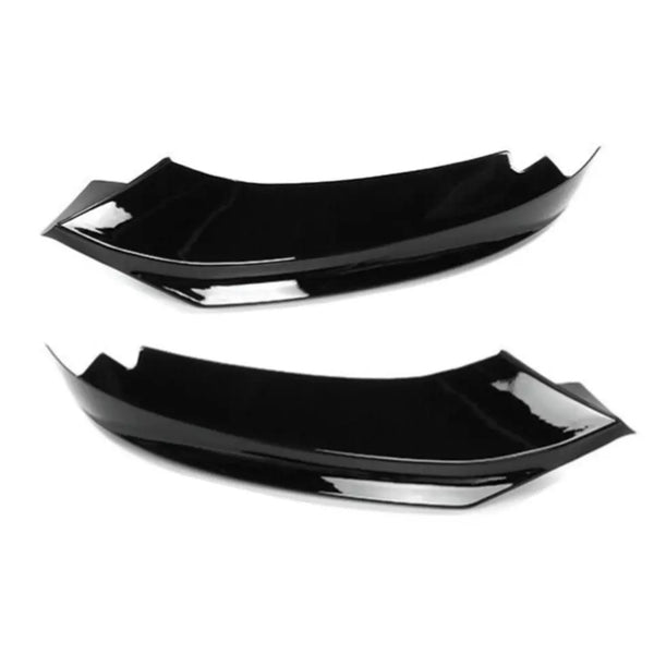 Two black, glossy aerodynamic car accessories lie side by side against a plain white background, showcasing their smooth, curved design and angular edges.