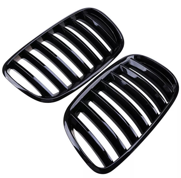Black kidney-shaped car grilles with multiple vertical slats are placed side by side against a white background, showcasing their sleek, glossy finish.