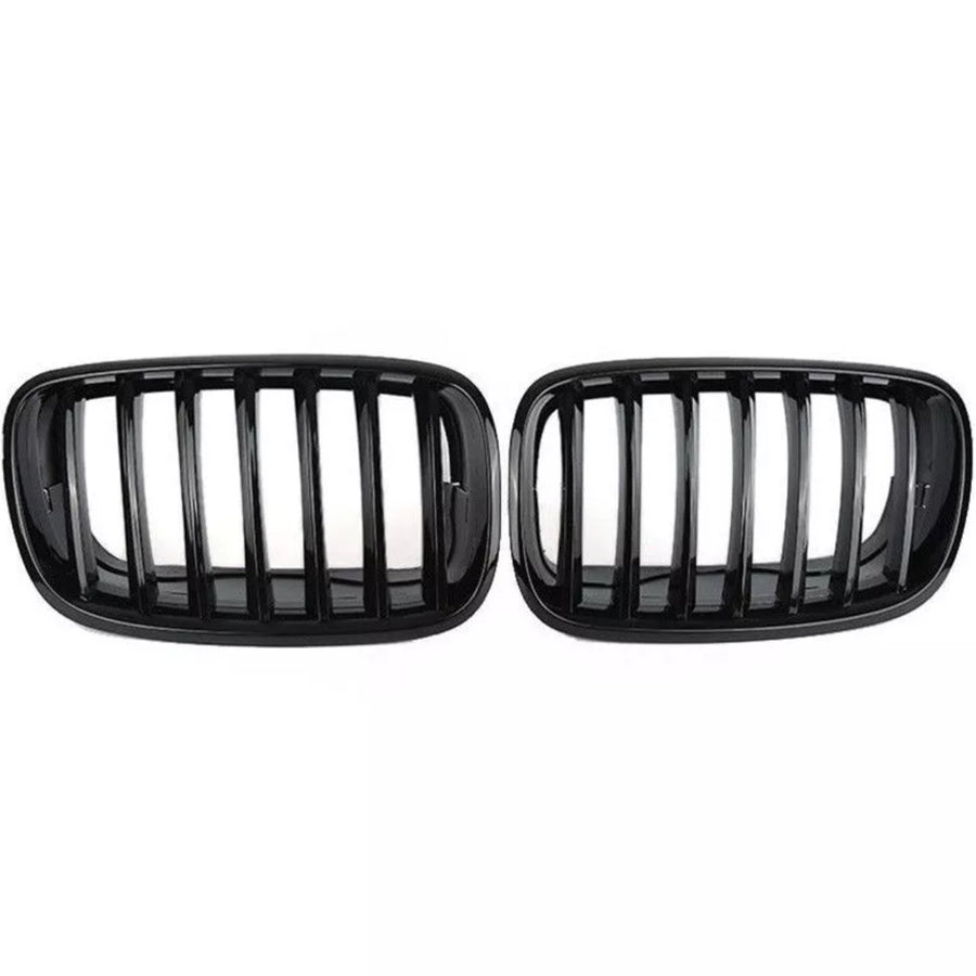 Two black car grilles with vertical slats are displayed side by side against a plain white background, showcasing a sleek automotive accessory design.