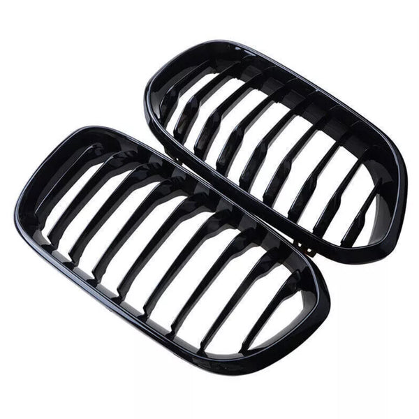 Two glossy black car grilles, each with multiple vertical slats, placed adjacent to each other against a white background.