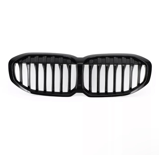 A glossy black car grille, featuring vertical slats, lies on a plain white background, designed to fit the front of a vehicle, enhancing its appearance and functionality.
