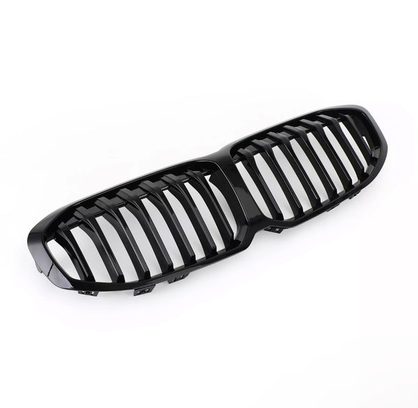 A glossy black car grille, featuring vertical slats, rests on a white background, designed for vehicle front-end styling and air flow.