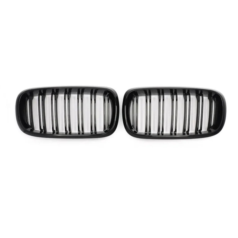 Two black car grilles, each with vertical slats, are positioned side by side against a plain white background.