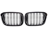 Two sleek, black car grilles with vertical slats are positioned side by side against a white background, suggesting a symmetrical, possibly automotive design focus.