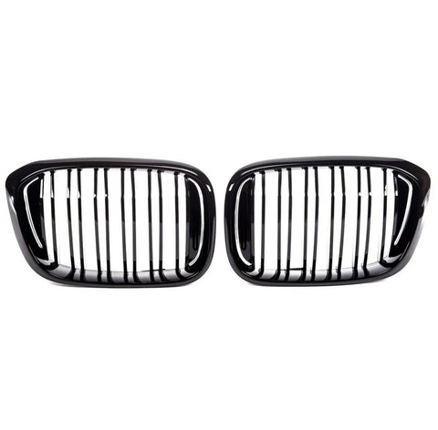 Two sleek, black car grilles with vertical slats are positioned side by side against a white background, suggesting a symmetrical, possibly automotive design focus.