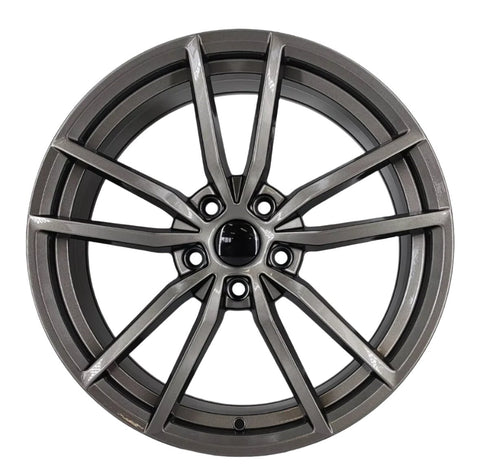 A metallic alloy wheel features a multi-spoke design, shown in a clean, isolated setting. The wheel has a glossy finish and a circular black center cap.