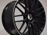 A black alloy wheel with a multi-spoke design, displaying 