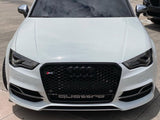 A white Audi S3 car is parked on a paved area. The black front grille features the Audi logo and 