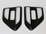 Two black, angular car air vent covers with rectangular openings positioned side by side on a white background.