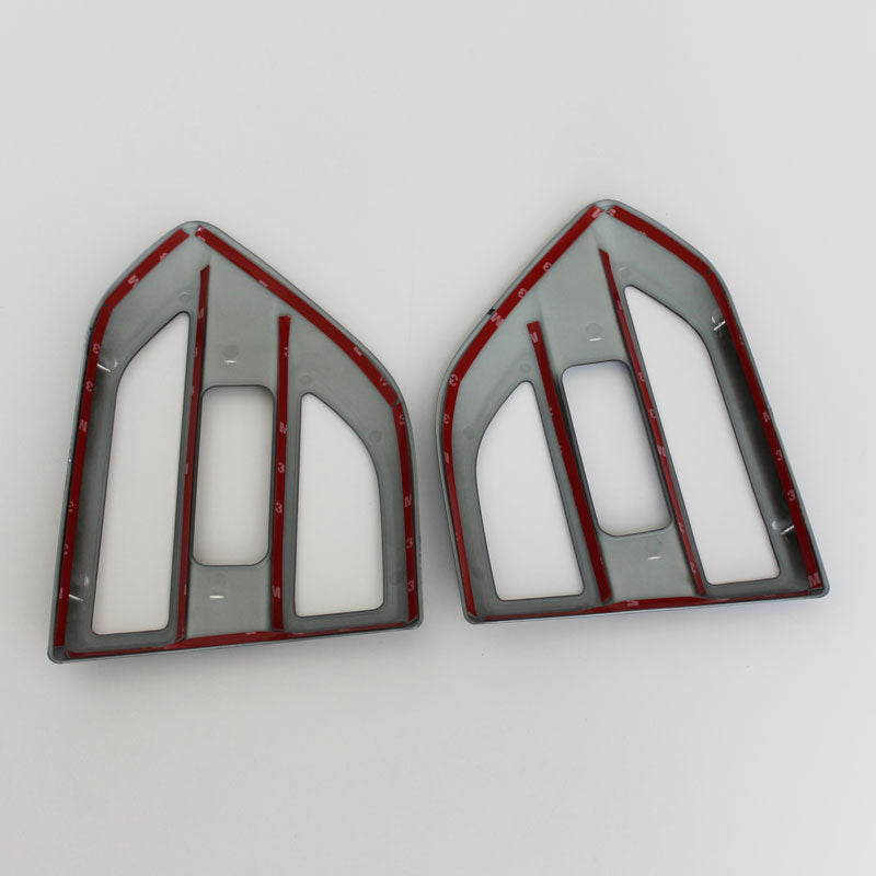 Two plastic frames, shaped like arrowheads, are placed side by side on a white background. Each frame is grey with red lining and features numbered notches along the edges.