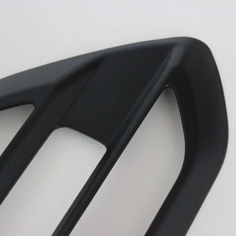 A black, angular car accessory with two rectangular openings is displayed on a plain white background.