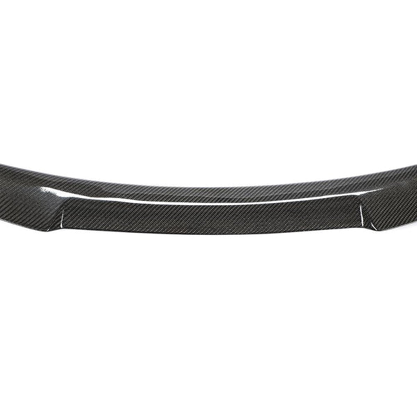 Carbon fiber car spoiler resting on a plain white background, showcasing its sleek, curved design and glossy texture, highlighting the material’s distinctive woven pattern.