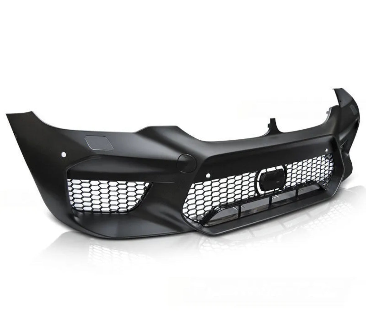 A black car front bumper with a honeycomb grille sits on a white reflective surface, displaying a sleek and aerodynamic design with empty light spaces.