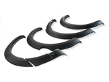Four black fender flares are arranged in a row, showcasing their curved and contoured design, on a plain white background.