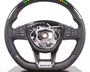 A carbon-fiber steering wheel features multifunction buttons on the sides and a digital display at the top. The center is missing, revealing internal mechanisms. Display text: "3000 RPM, 120 km/h."
