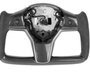 A carbon-fiber steering wheel frame, without a central panel or buttons, rests on a plain white background, showing sleek ergonomic grips and precise craftsmanship.