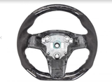 A car steering wheel, lacking its central cover, displays its bare metal core and attachment points, surrounded by black material, set against a plain white background.