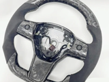 A steering wheel with a marbled pattern and missing central cover, exposing internal wiring and mechanisms, set against a plain white background.