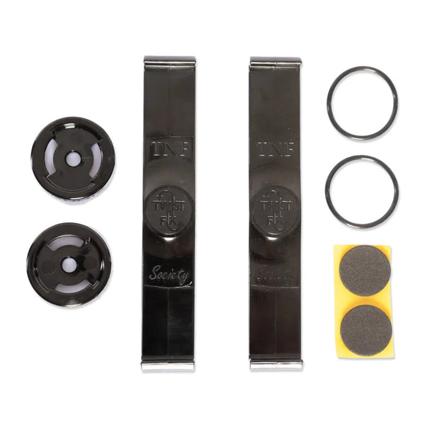 Metal clips labeled "TWF" and "Society" are placed centrally. Surrounding them are two black circular discs, two rubber rings, and a small yellow square with two round gray pads.