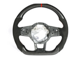 A carbon-fiber steering wheel with a red stripe at the top and a partially exposed interior mechanism, displayed against a plain white background.