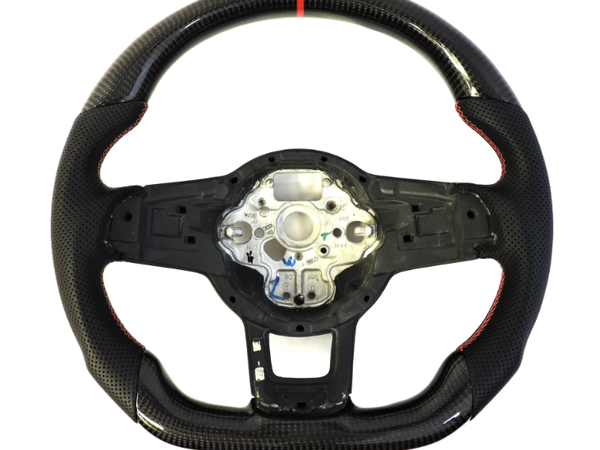 A carbon fiber steering wheel with red accents, featuring a central metallic mounting bracket. The wheel is laid on a plain white background, highlighting its textured grip.