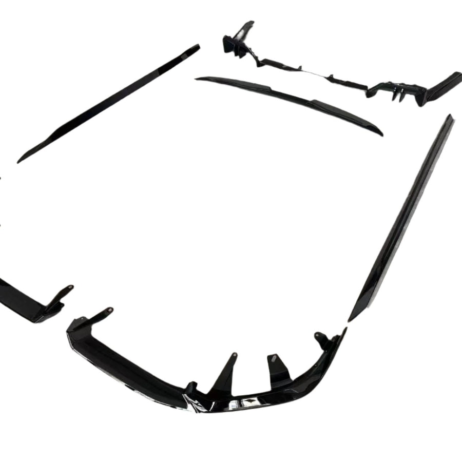 Black car body kit components are arranged on a plain white background. The pieces include bumpers and side skirts, designed to enhance vehicle aerodynamics and appearance.