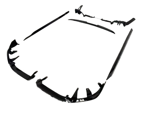 Black car body kit components are arranged on a plain white background. The pieces include bumpers and side skirts, designed to enhance vehicle aerodynamics and appearance.