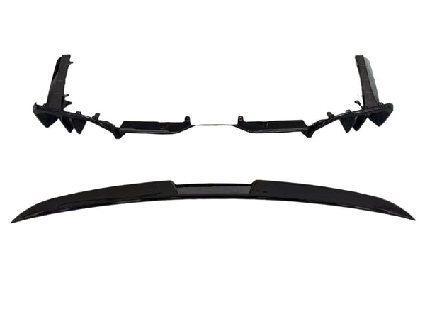 Two sleek black car parts, likely a bumper and a spoiler, are aligned parallel on a white background, showcasing their aerodynamic design and smooth surfaces.