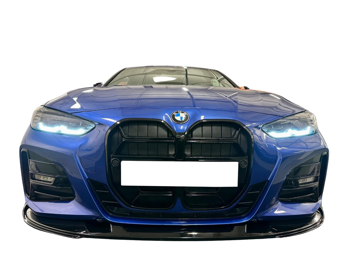 A blue car with illuminated headlights is facing forward, showcasing its prominent black grille and a visible logo, set against a black background.