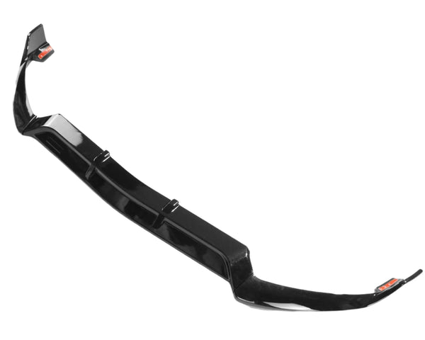 A black car front splitter lies on a white background. It features a glossy finish and has aerodynamic curves at the edges for performance enhancement.