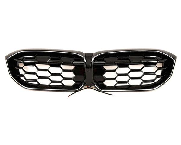 A black car grille with honeycomb design, featuring two separate sections joined in the center. Wires protrude from the middle, suggesting electronic integration. The background is plain white.