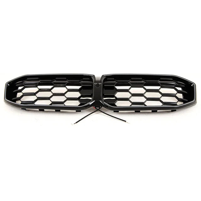 A hexagonal-patterned car grille with black finish, featuring a central wiring connection, is positioned on a plain white background.